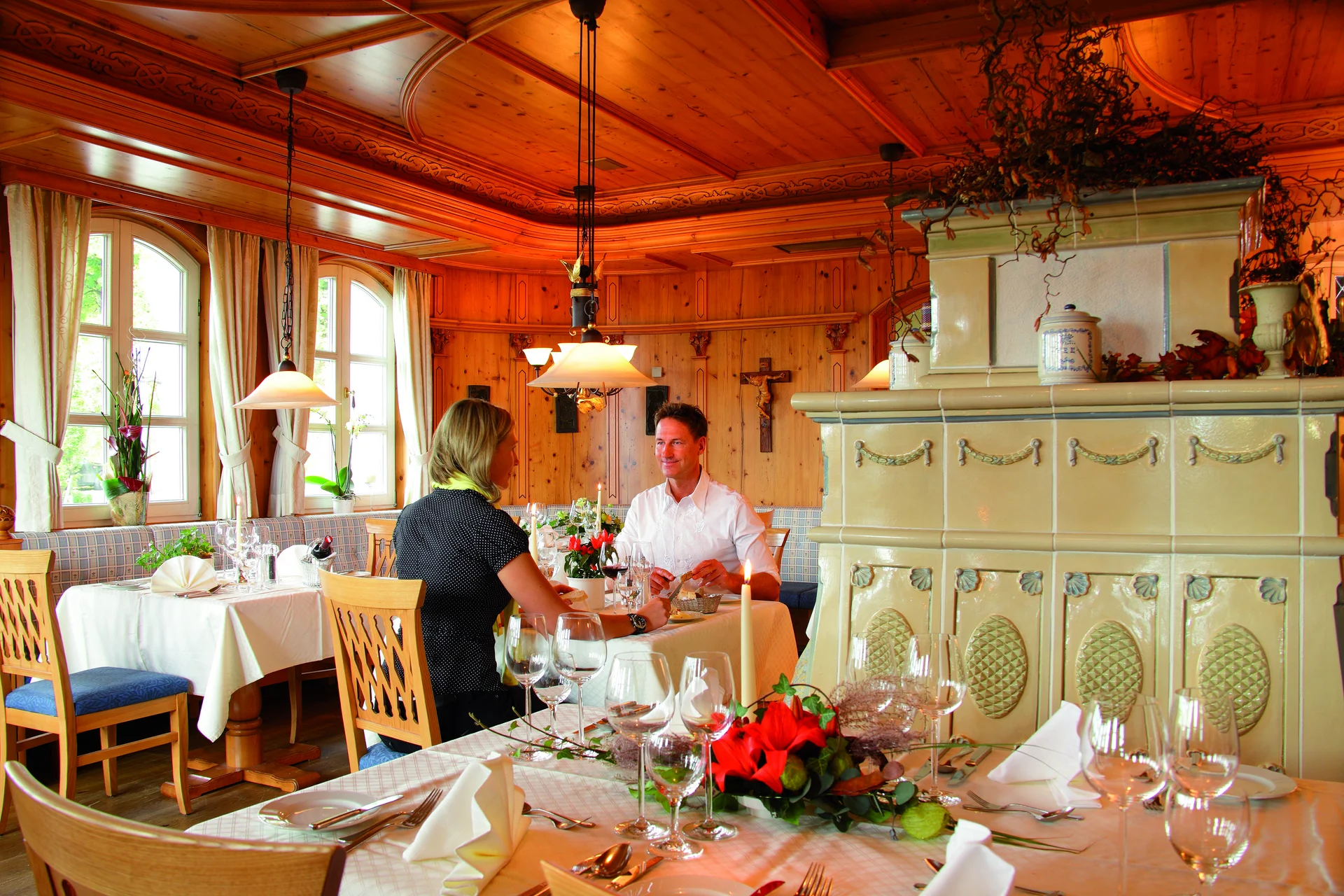 Paar sitzt in einem gemütlichen, holzverkleideten Restaurant mit Tischdekoration
