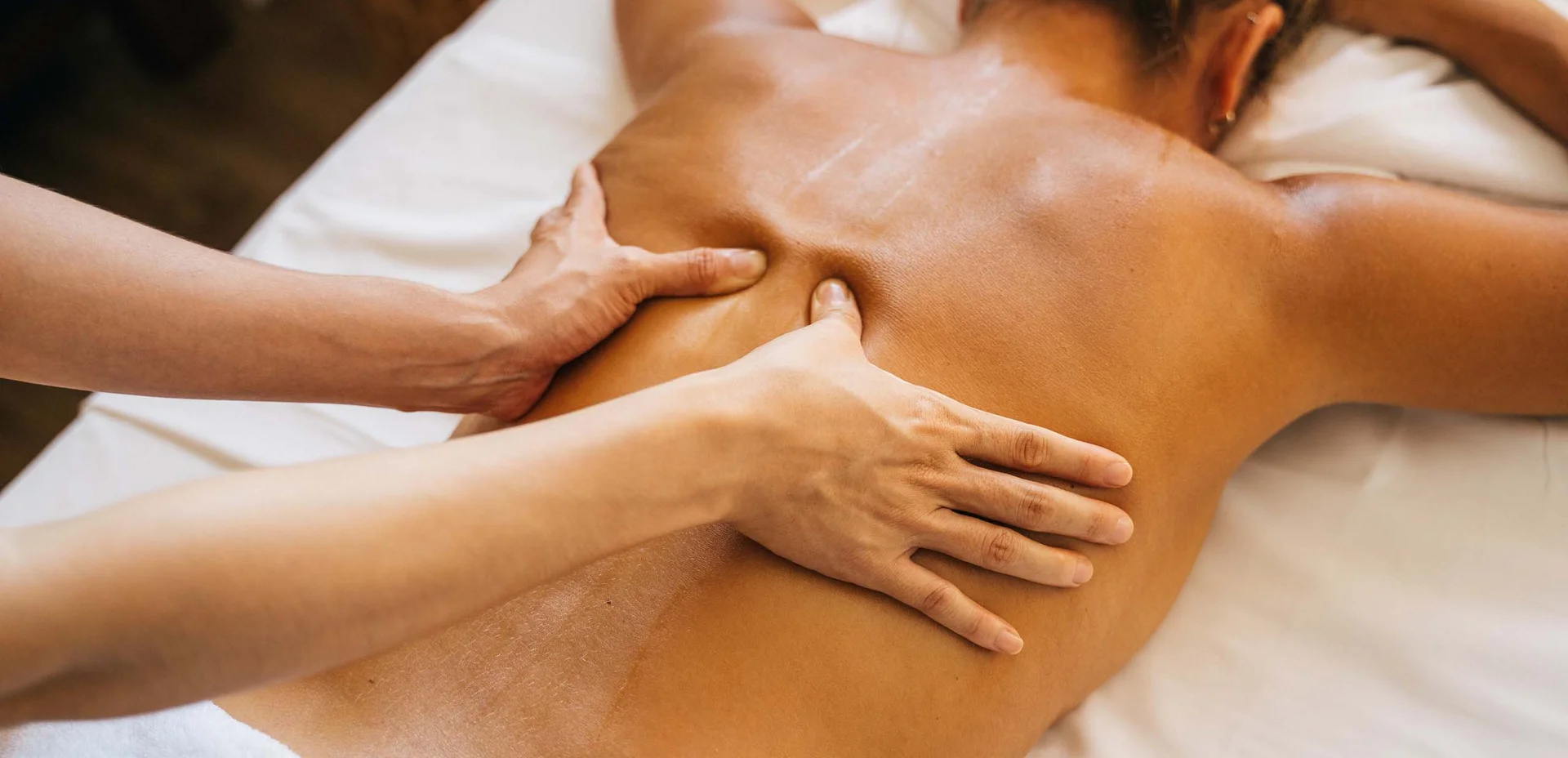 Frau erhält Rückenmassage in Spa-Umgebung