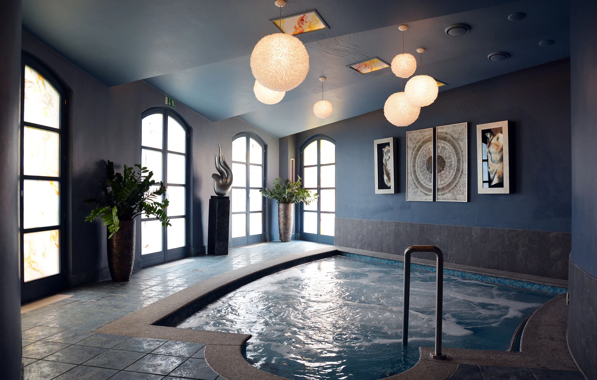 Modernes Whirlpool-Becken in elegantem Raum mit großer Fensterfront und Kunst an der Wand