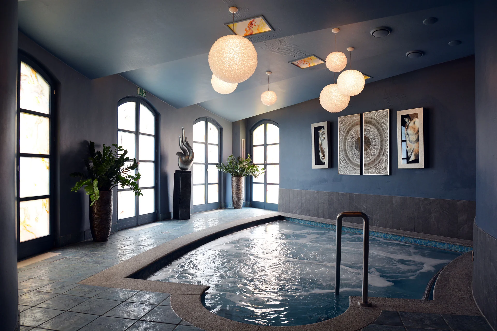 Modernes Whirlpool-Becken in elegantem Raum mit großer Fensterfront und Kunst an der Wand