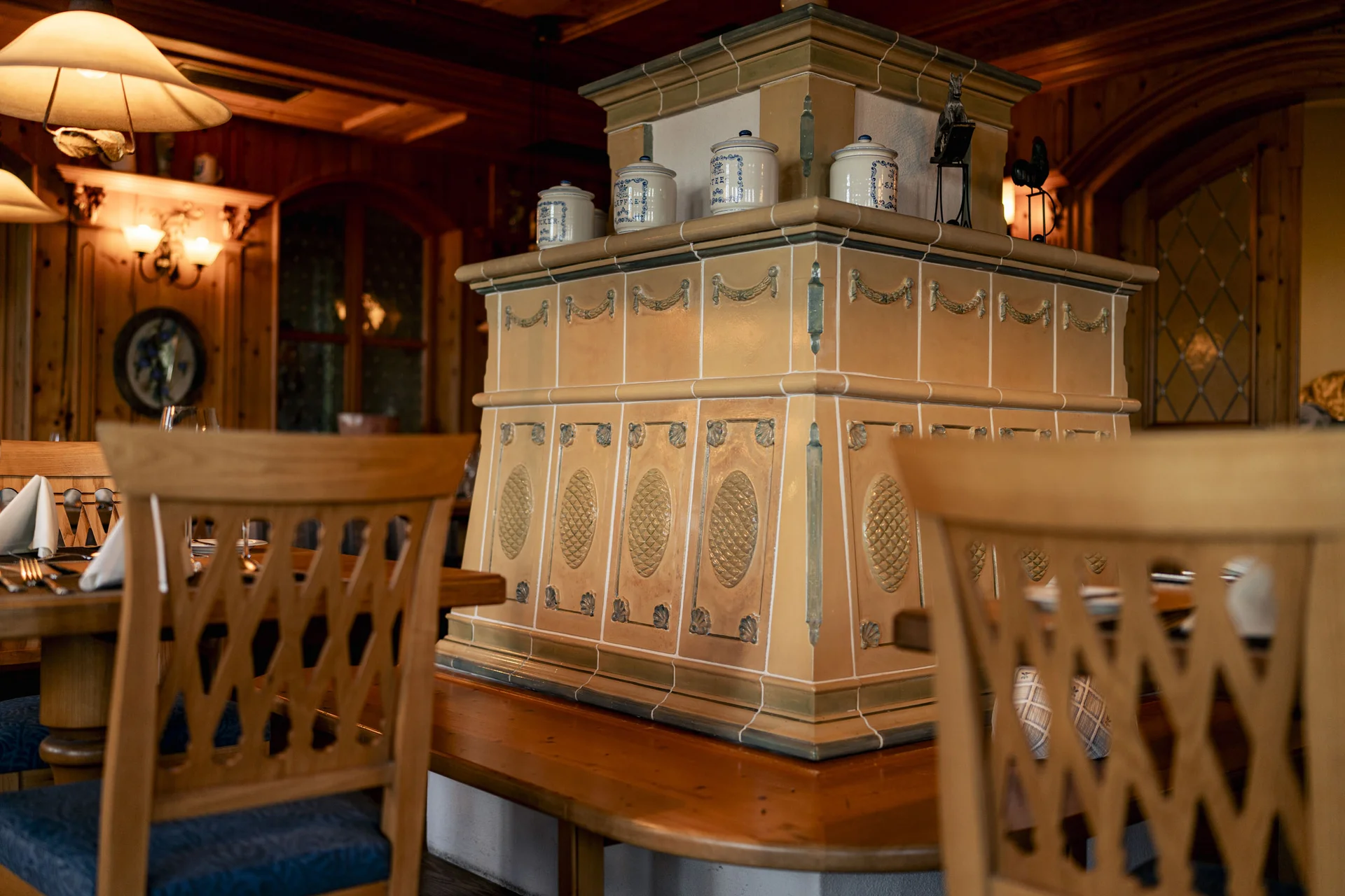 Traditioneller Kachelofen in gemütlichem, holzverkleidetem Restaurant