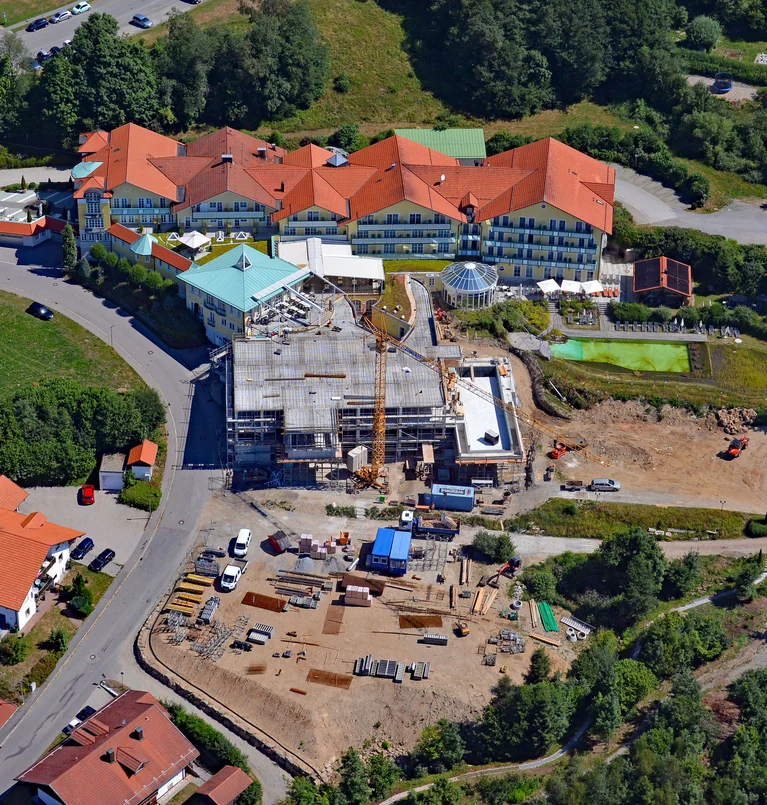 Luftaufnahme eines Hotels mit rotem Dach und angrenzender Baustelle