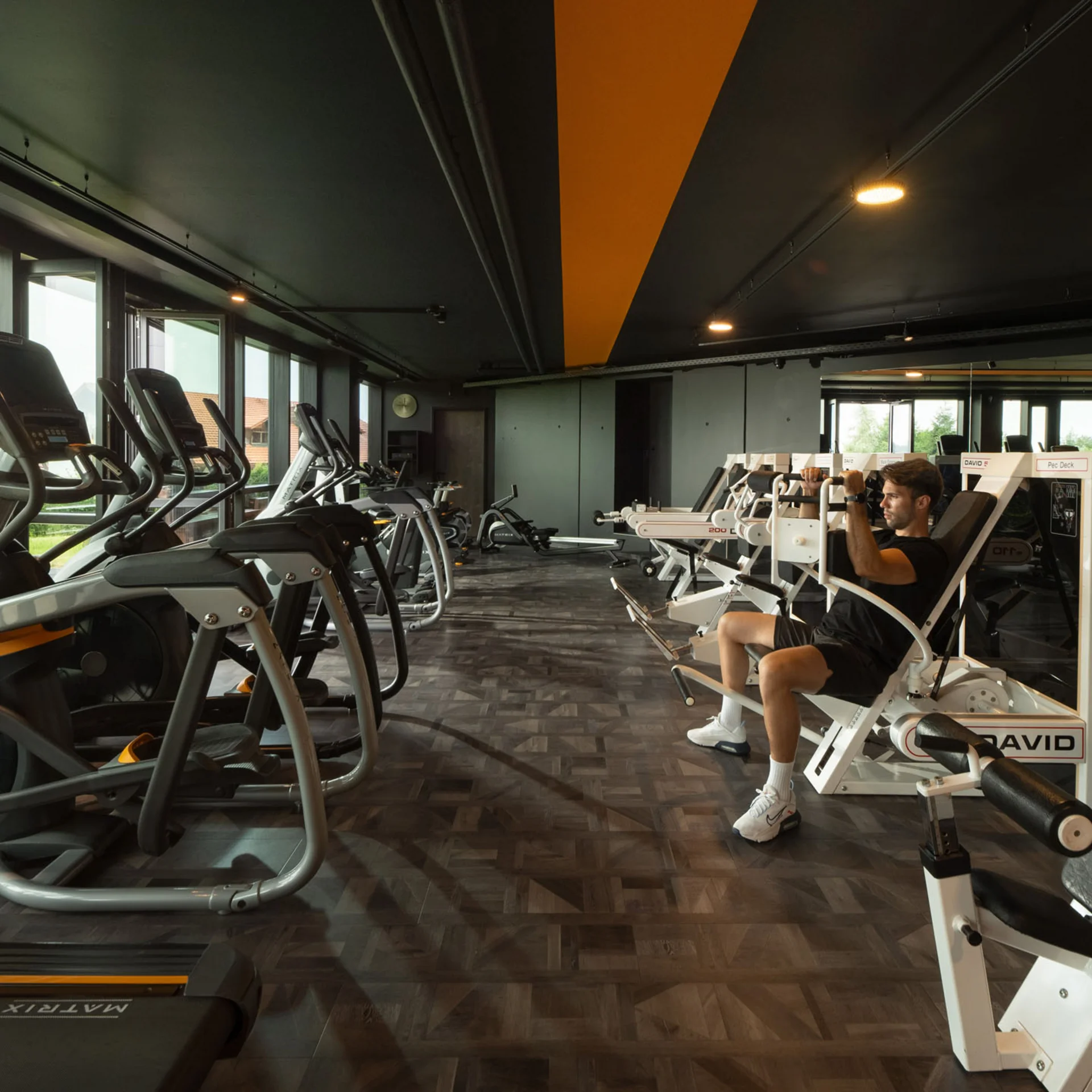 Mann trainiert an Fitnessgeräten in einem modernen Fitnessstudio
