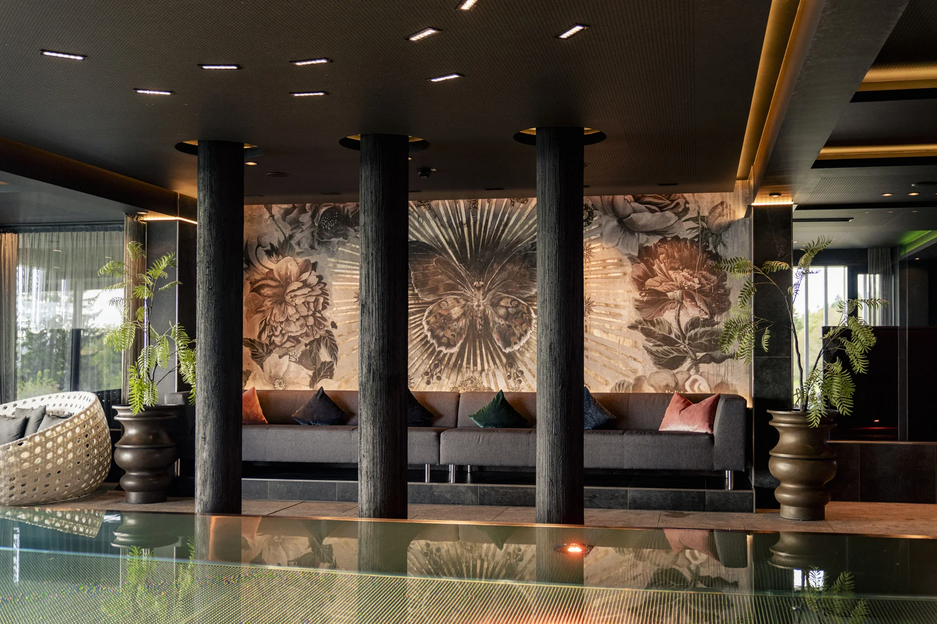 Moderner Lounge-Bereich mit gemusterten Kissen und einer großen Wanddekoration