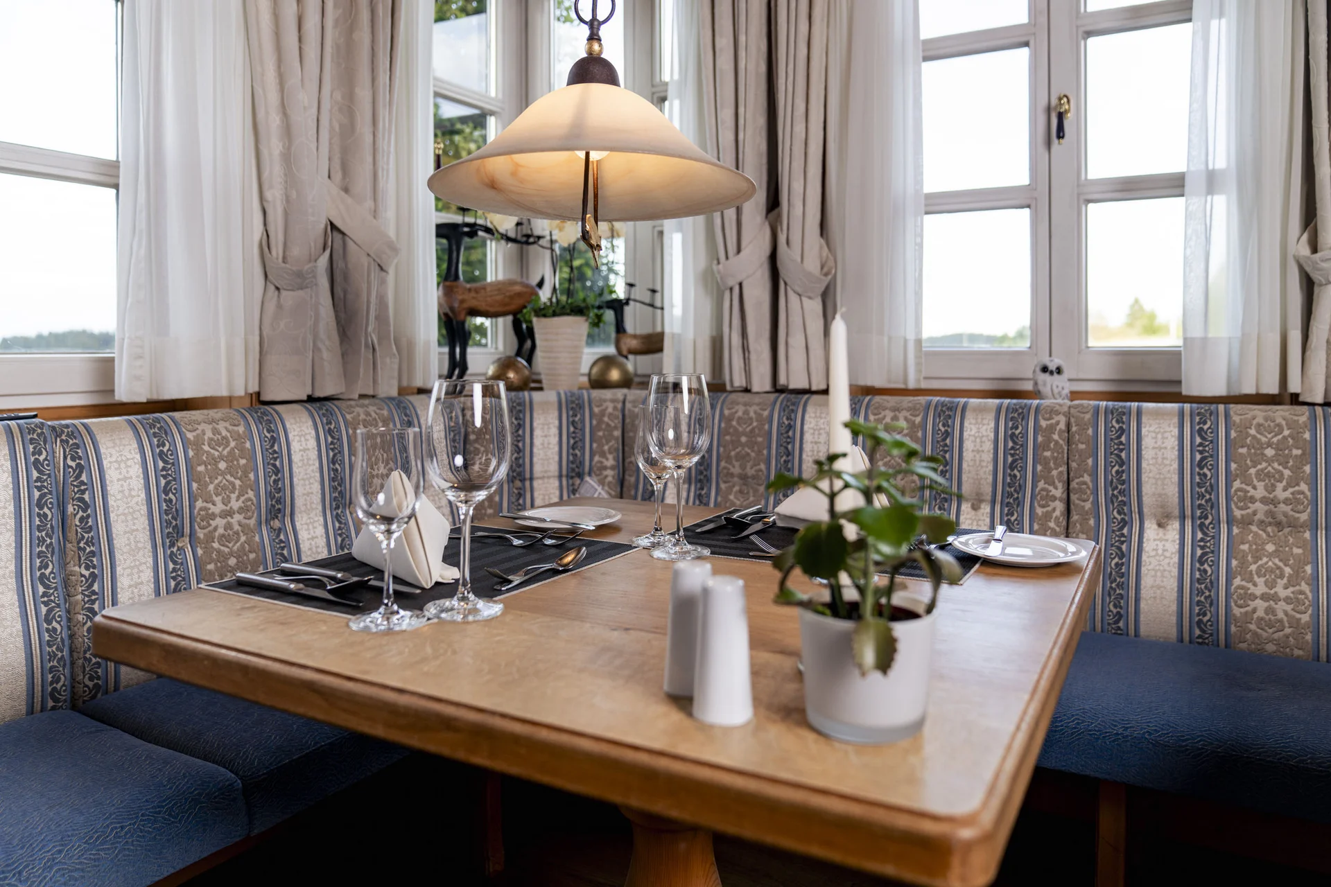 Gemütliche Essecke mit blau-gemusterten Sitzpolstern und Holztisch