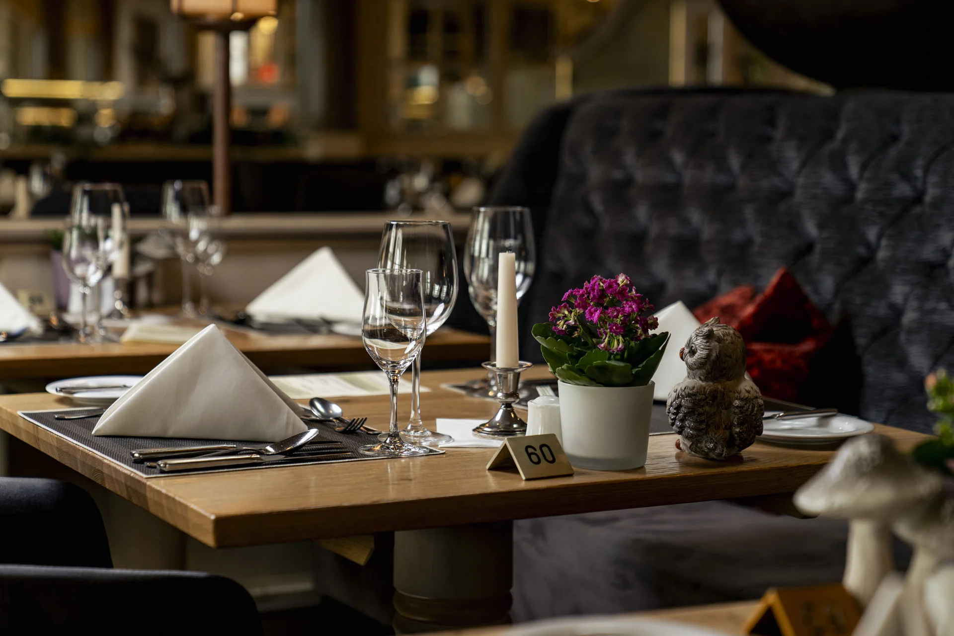 Eleganter gedeckter Restauranttisch mit Blumen und Kerze