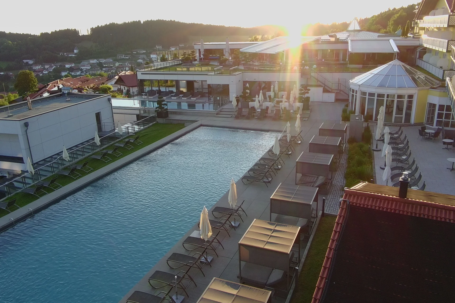 Hotel mit großem Pool und Sonnenuntergang im Hintergrund