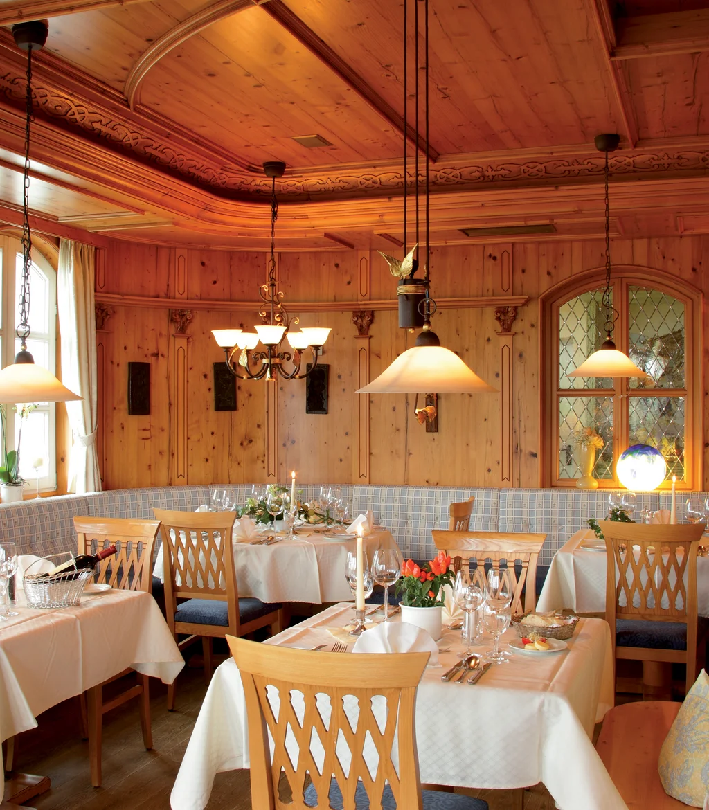Gemütliches Restaurant mit Holzvertäfelung und eingedeckten Tischen