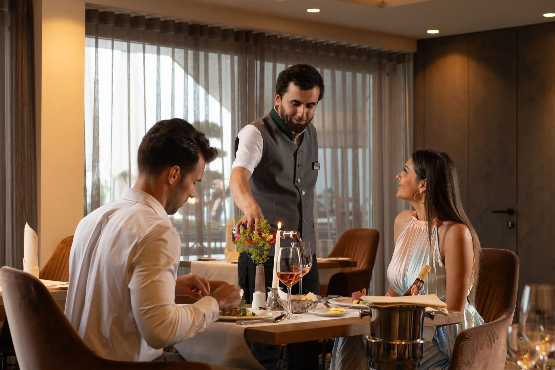 Kellner serviert Gästen Wein im eleganten Restaurant