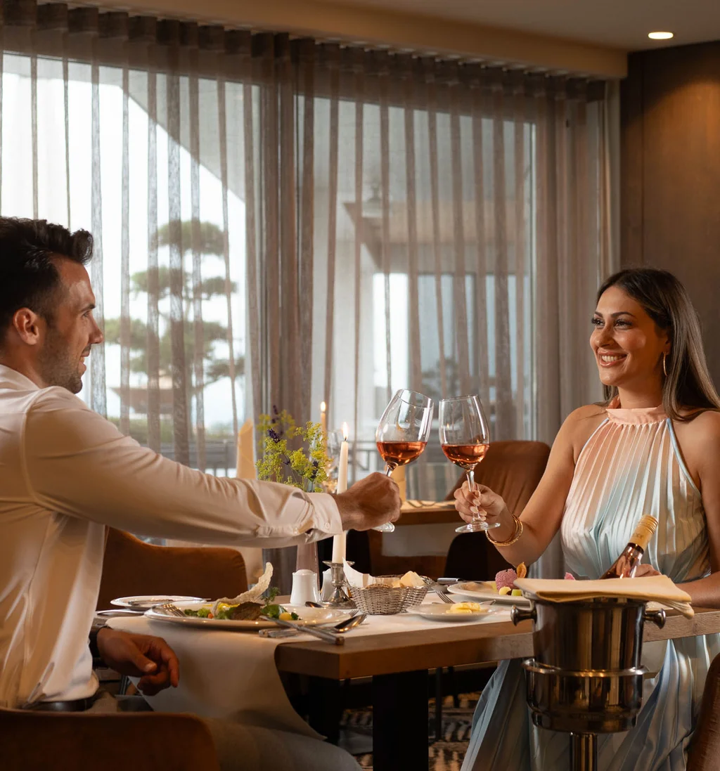 Paar stößt mit Wein in einem stilvollen Restaurant an