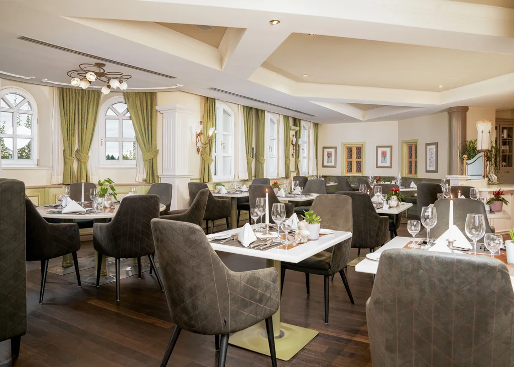 Elegantes Restaurant mit gedeckten Tischen und gepolsterten Stühlen