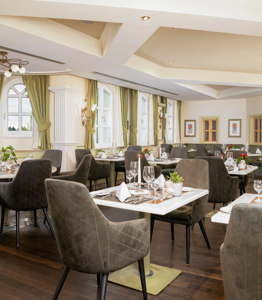 Elegantes Restaurant mit gedeckten Tischen und gepolsterten Stühlen