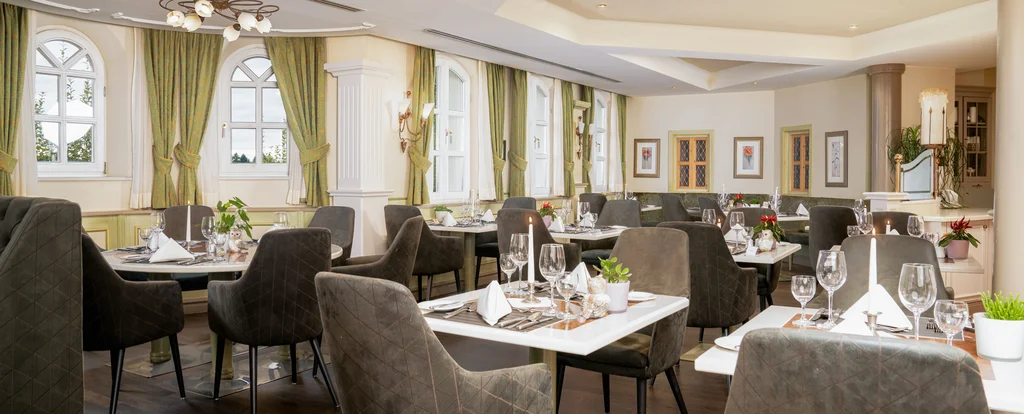 Elegantes Restaurant mit gedeckten Tischen und gepolsterten Stühlen