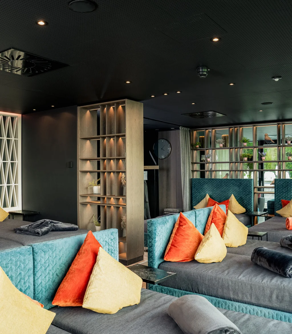 Moderne Lounge mit bunten Kissen und gedämpfter Beleuchtung
