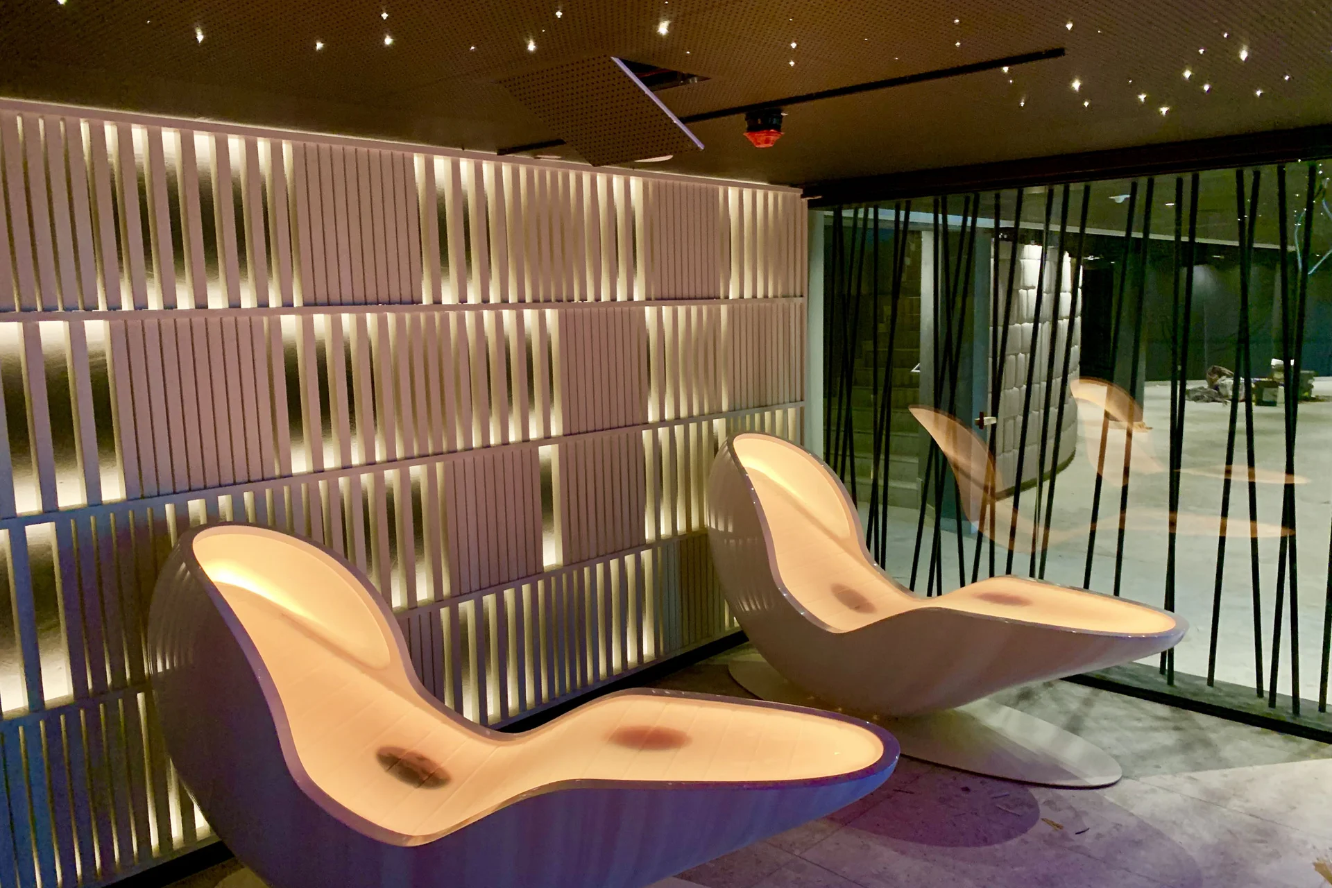 Moderne Lounge mit geschwungenen Stühlen und warmen Lichtakzenten