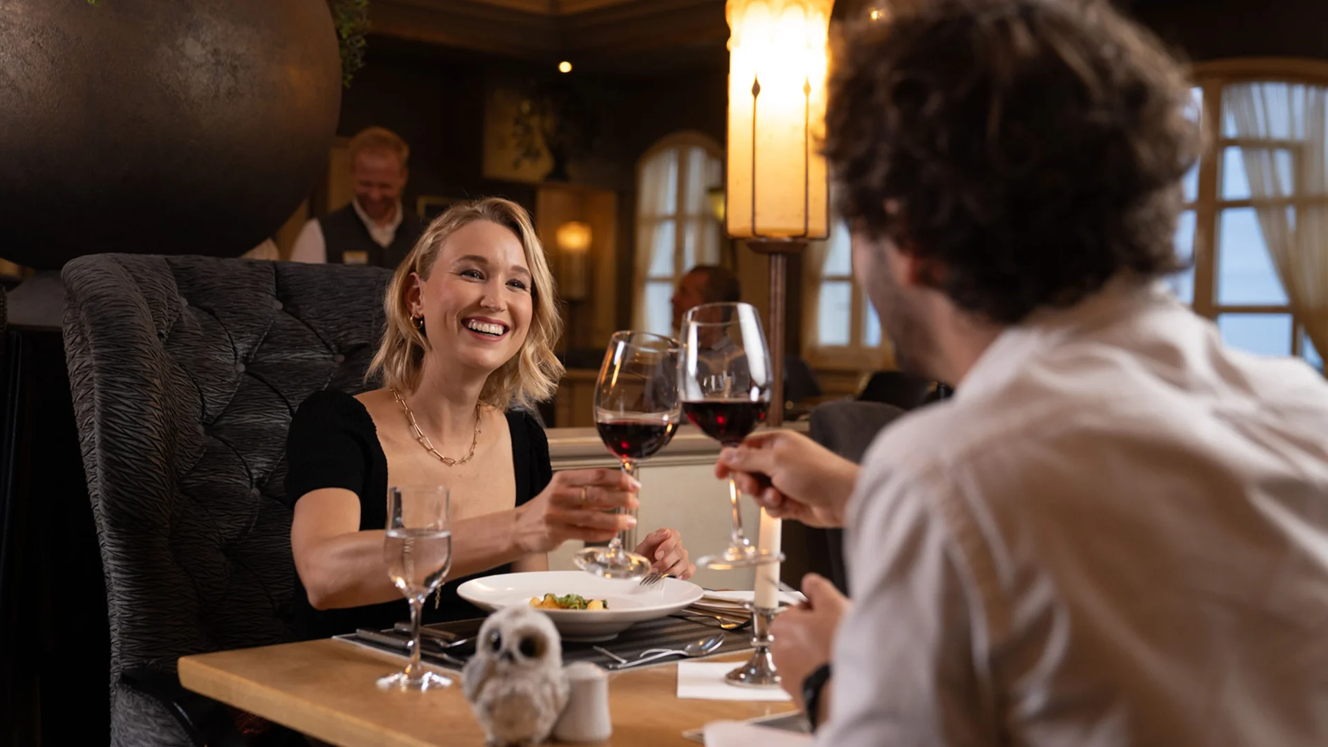 Paar stößt beim Essen im Restaurant mit Rotwein an