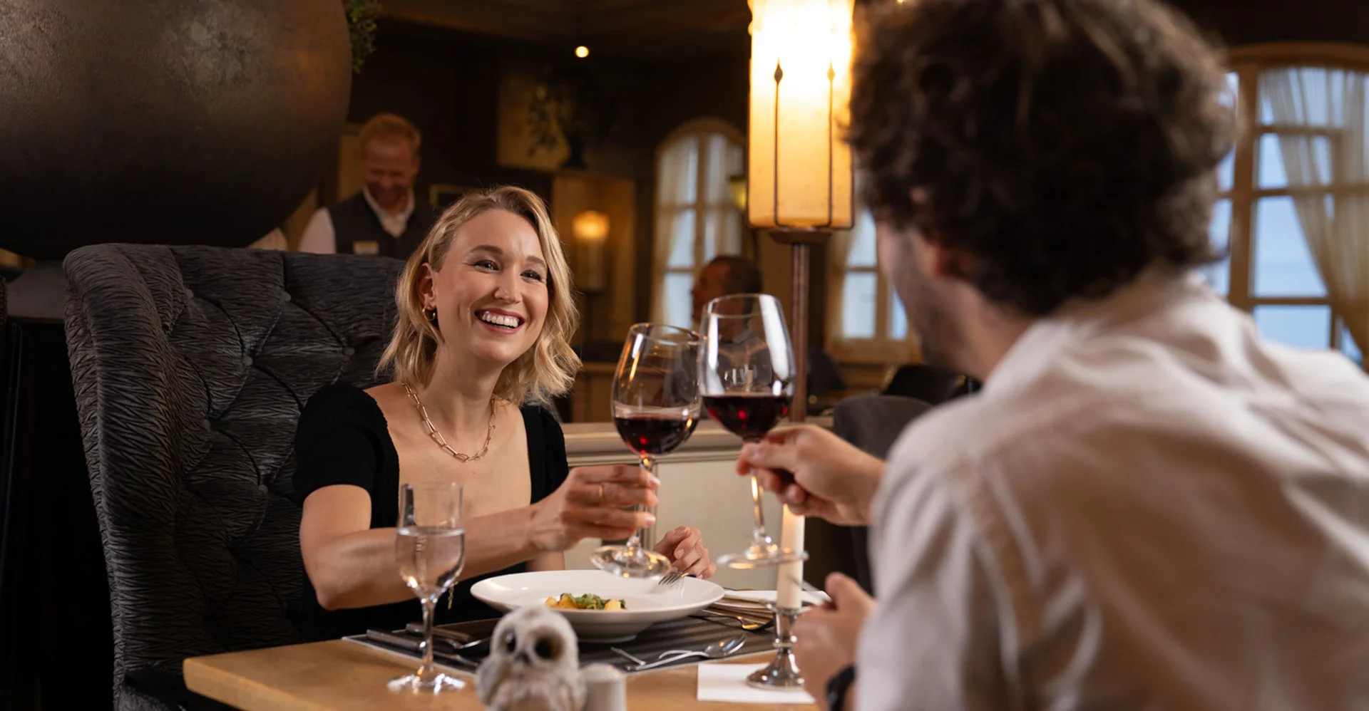 Paar stößt beim Essen im Restaurant mit Rotwein an