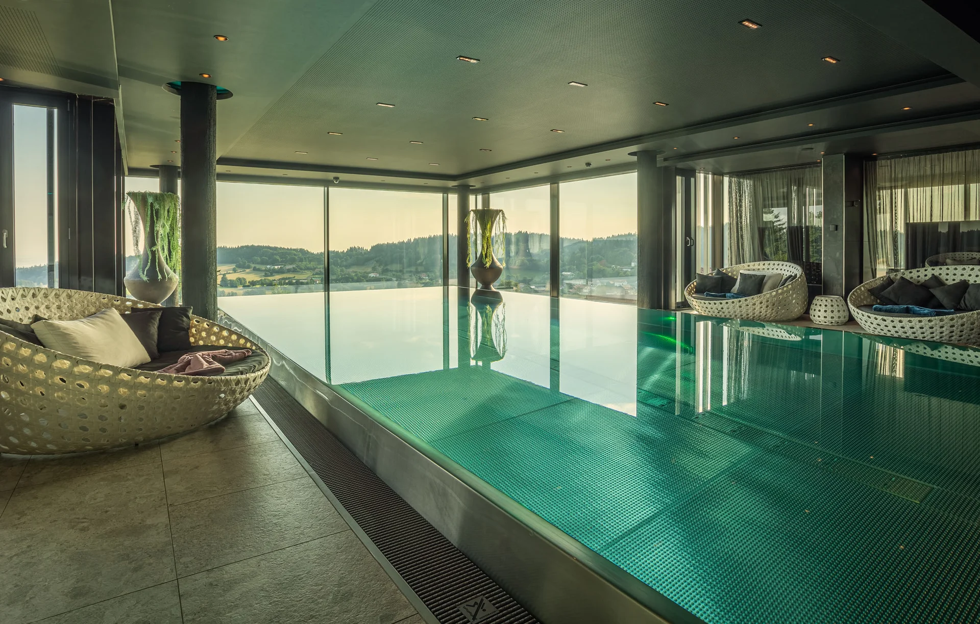 Moderner Innenpool mit Panoramablick und gemütlichen Sitzbereichen