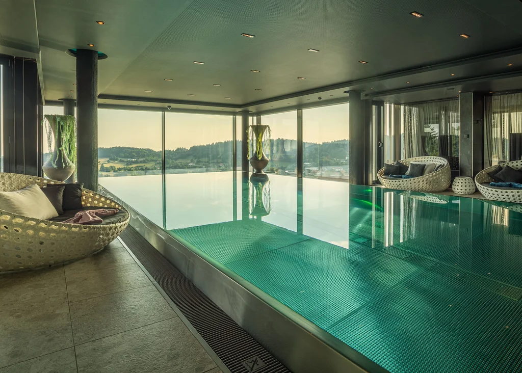 Die Adresse für Wellness in Bayern: Ihr Hotel in St. Englmar Moderner Innenpool mit Panoramablick und gemütlichen Sitzbereichen