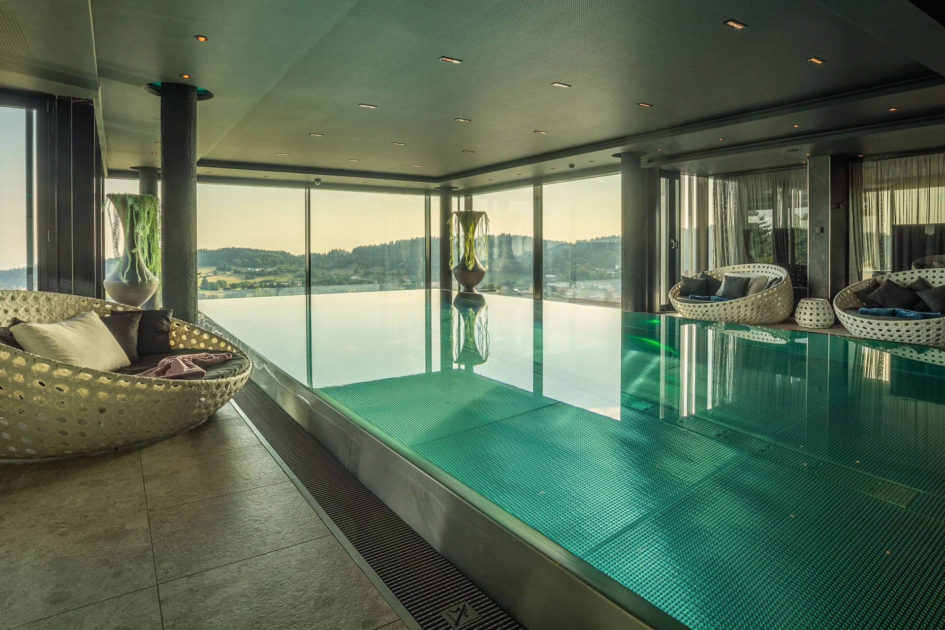 Moderner Innenpool mit Panoramablick und gemütlichen Sitzbereichen