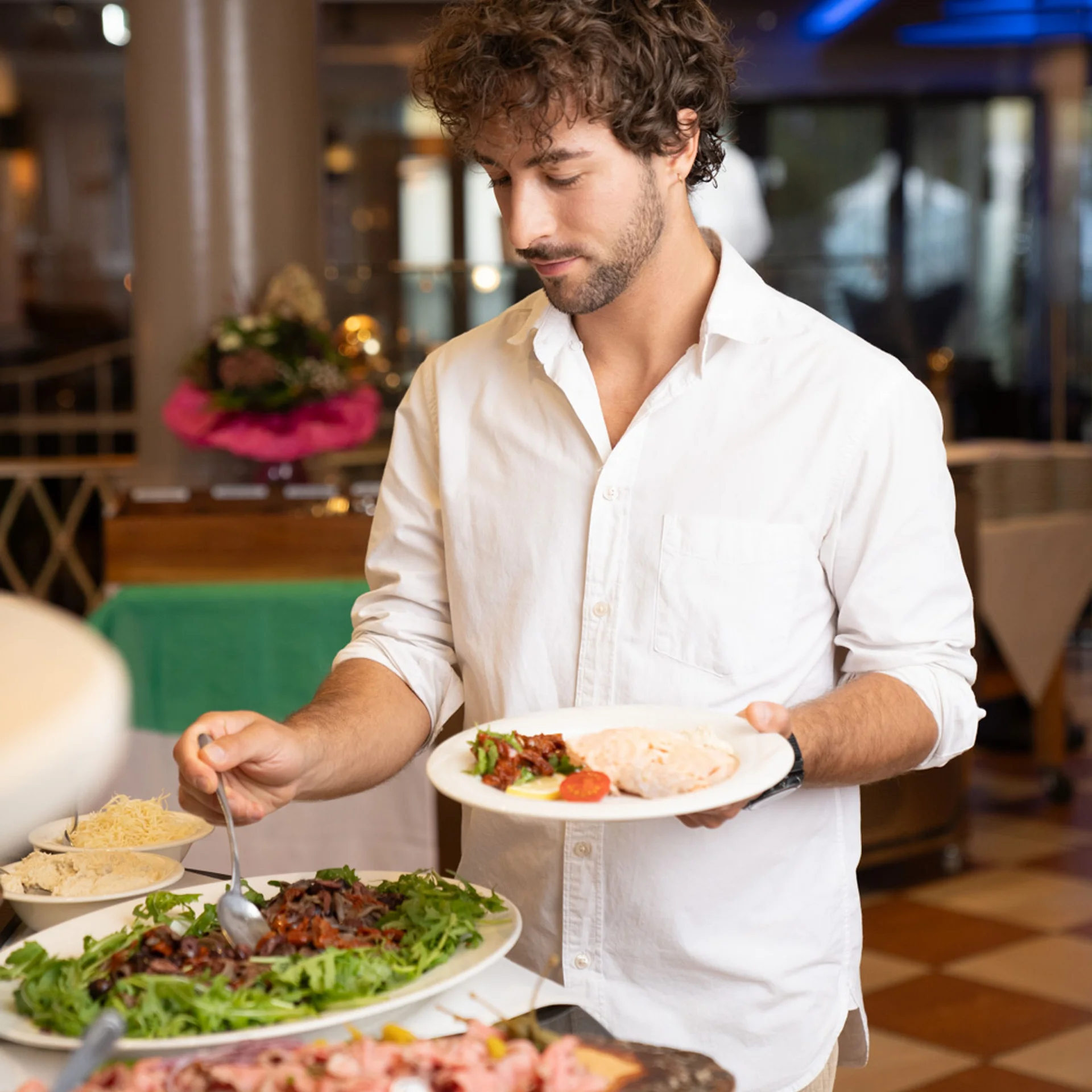 Junger Mann bedient sich an Buffet in Restaurant