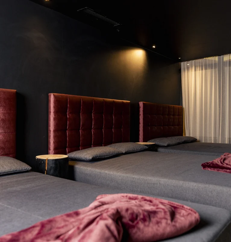 Dunkles Zimmer mit Sitzbänken und roten Polsterlehnen an der Wand