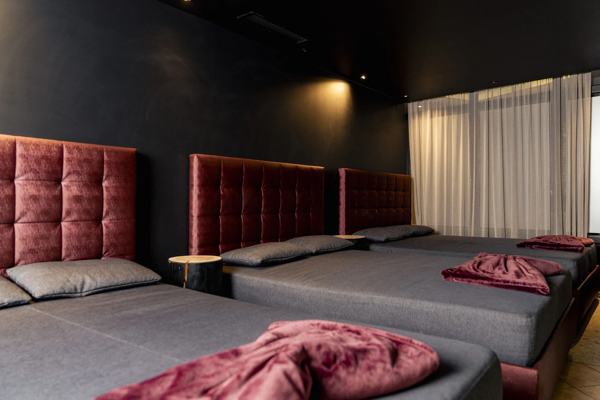 Dunkles Zimmer mit Sitzbänken und roten Polsterlehnen an der Wand