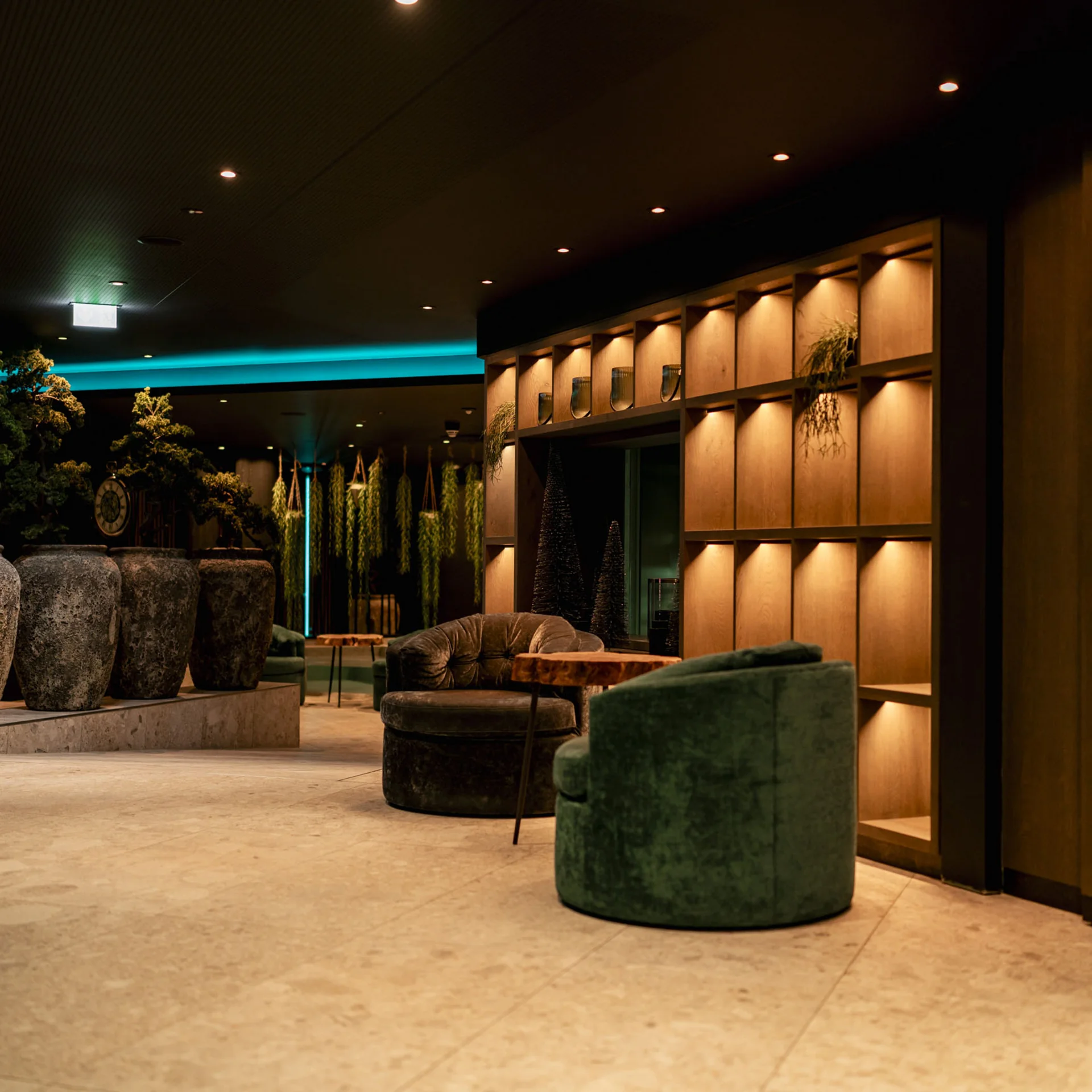 Modern eingerichteter Lounge-Bereich mit großen Vasen und indirekter Beleuchtung