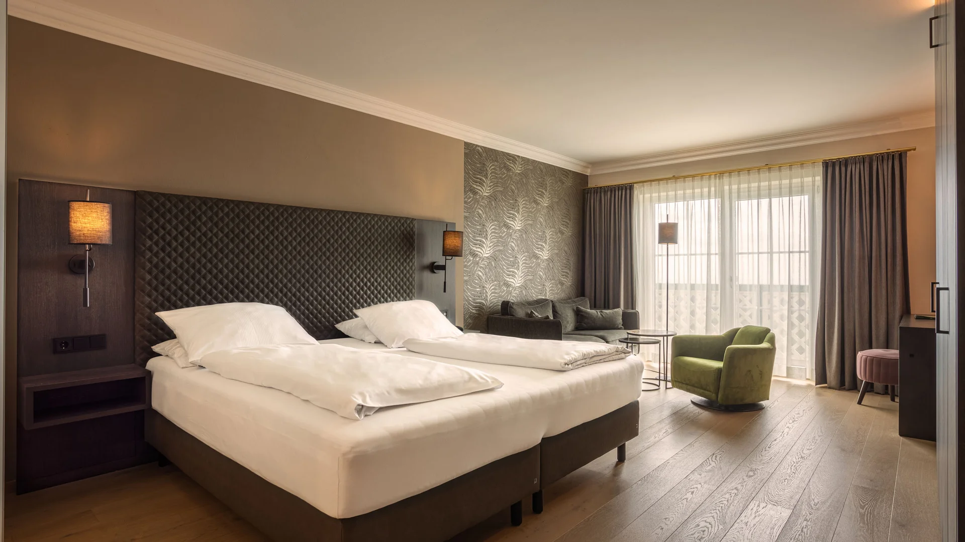 Modernes Hotelzimmer mit zwei Betten und gemütlicher Sitzecke