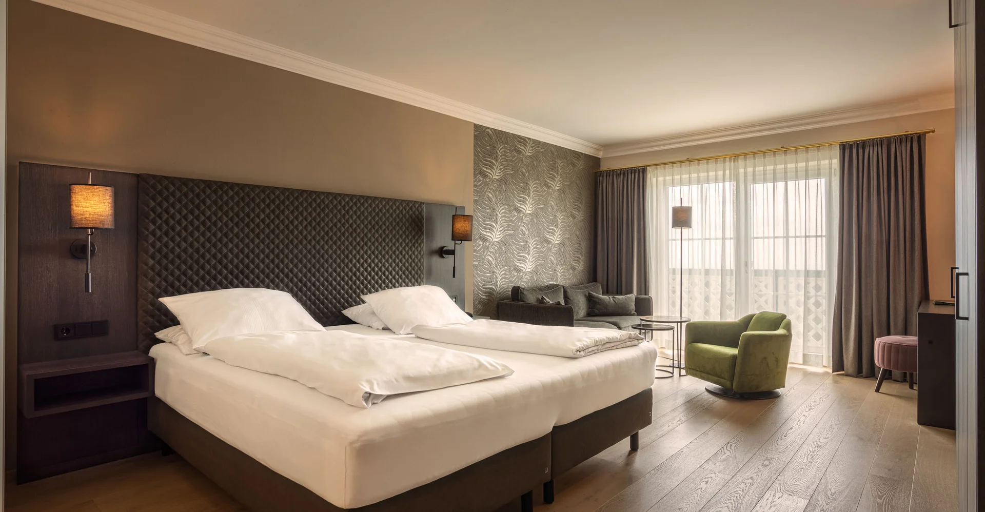 Modernes Hotelzimmer mit zwei Betten und gemütlicher Sitzecke