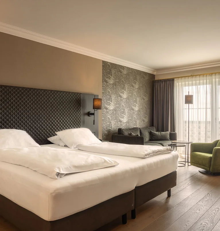 Die Adresse für Wellness in Bayern: Ihr Hotel in St. Englmar Modernes Hotelzimmer mit zwei Betten und gemütlicher Sitzecke