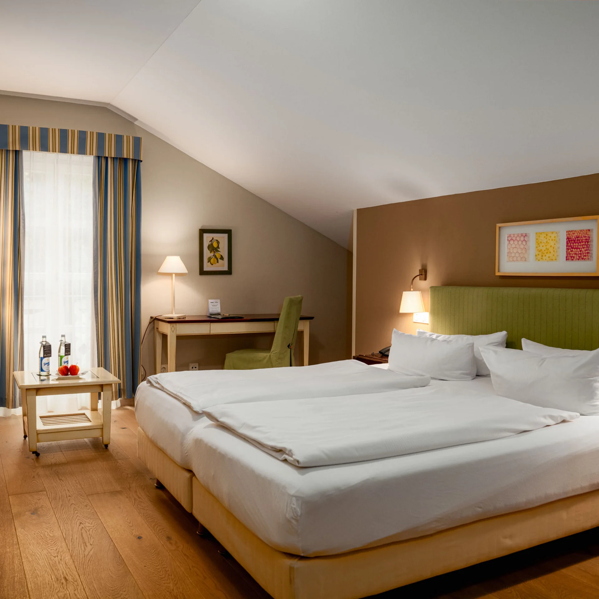 Helles Hotelzimmer mit Doppelbett, Schreibtisch und gemütlicher Sitzecke