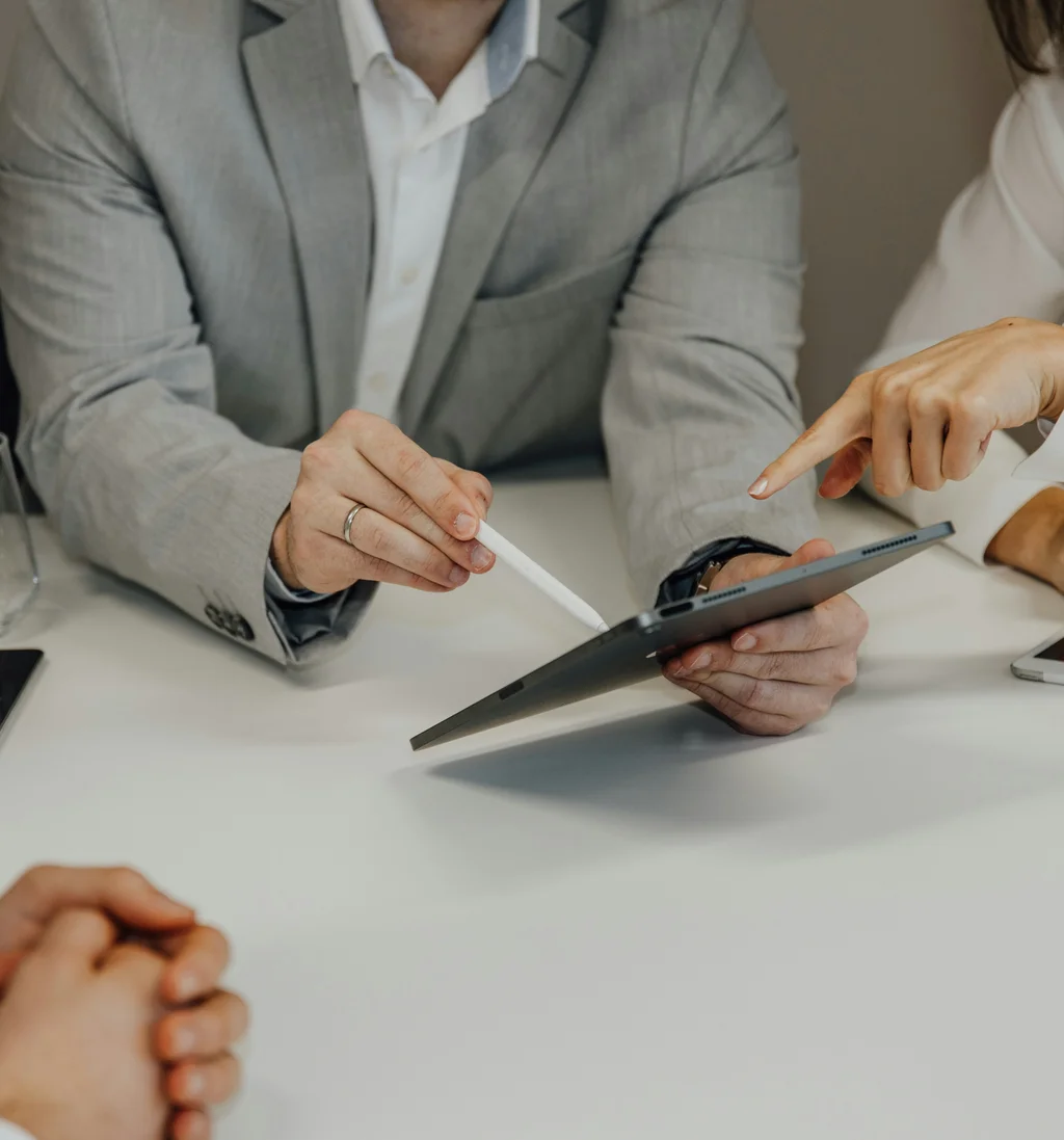 Geschäftsbesprechung mit Tablet und Handschriften am Tisch