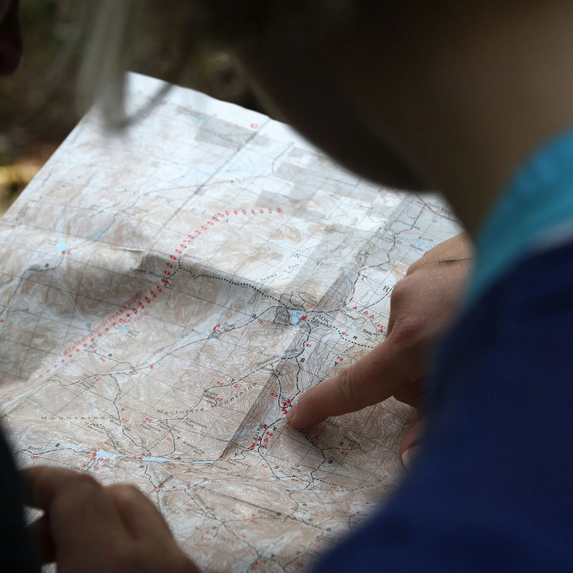 Person liest Karte im Freien beim Wandern