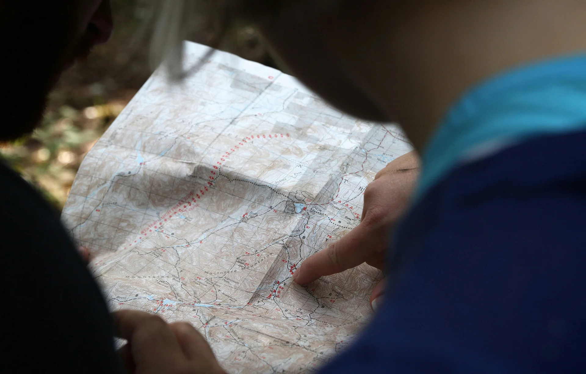 Person liest Karte im Freien beim Wandern
