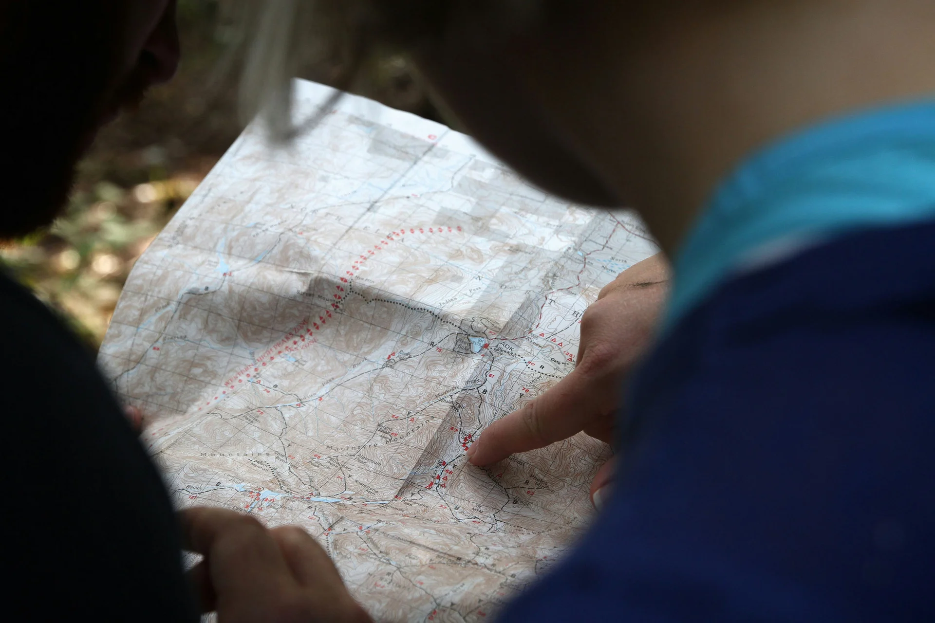 Person liest Karte im Freien beim Wandern