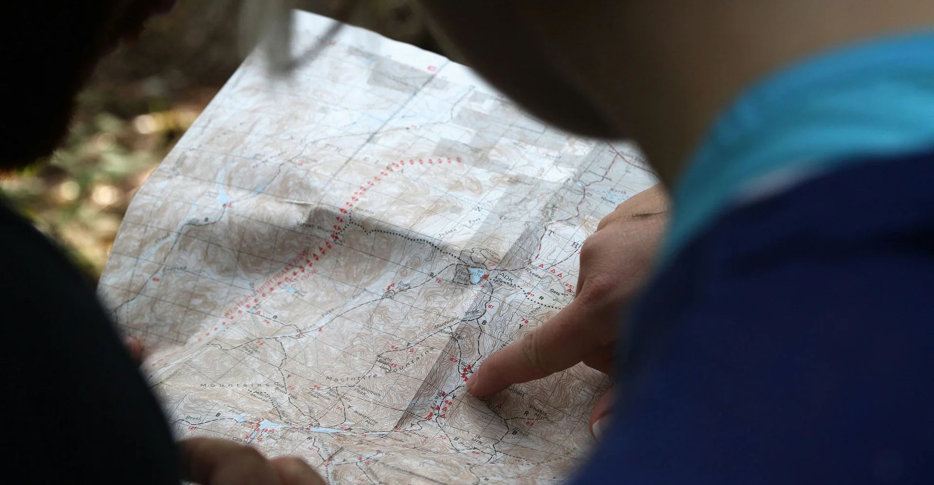 Person liest Karte im Freien beim Wandern