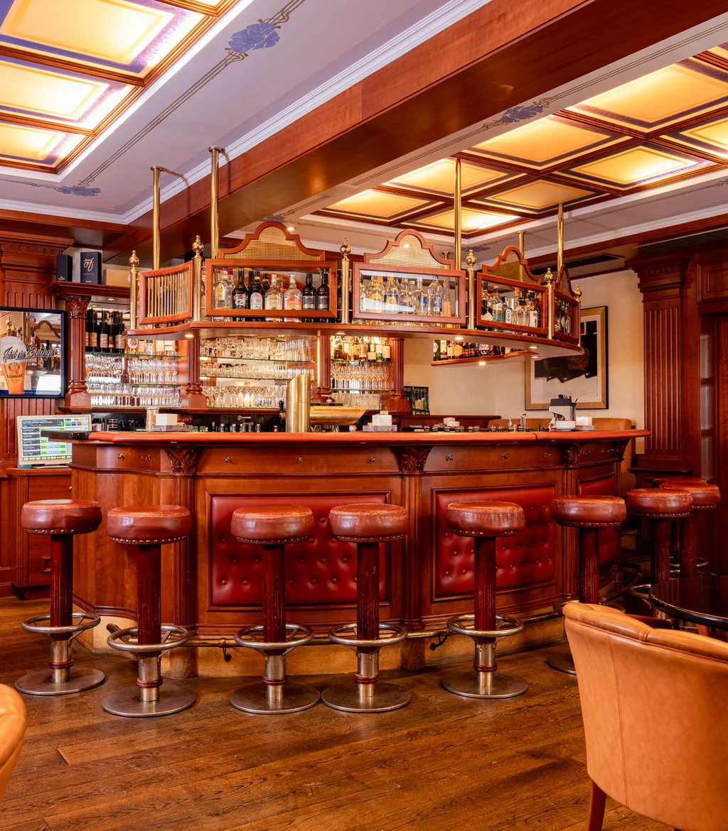 Traditionelle Bar mit Holzverkleidung und Ledersitzen